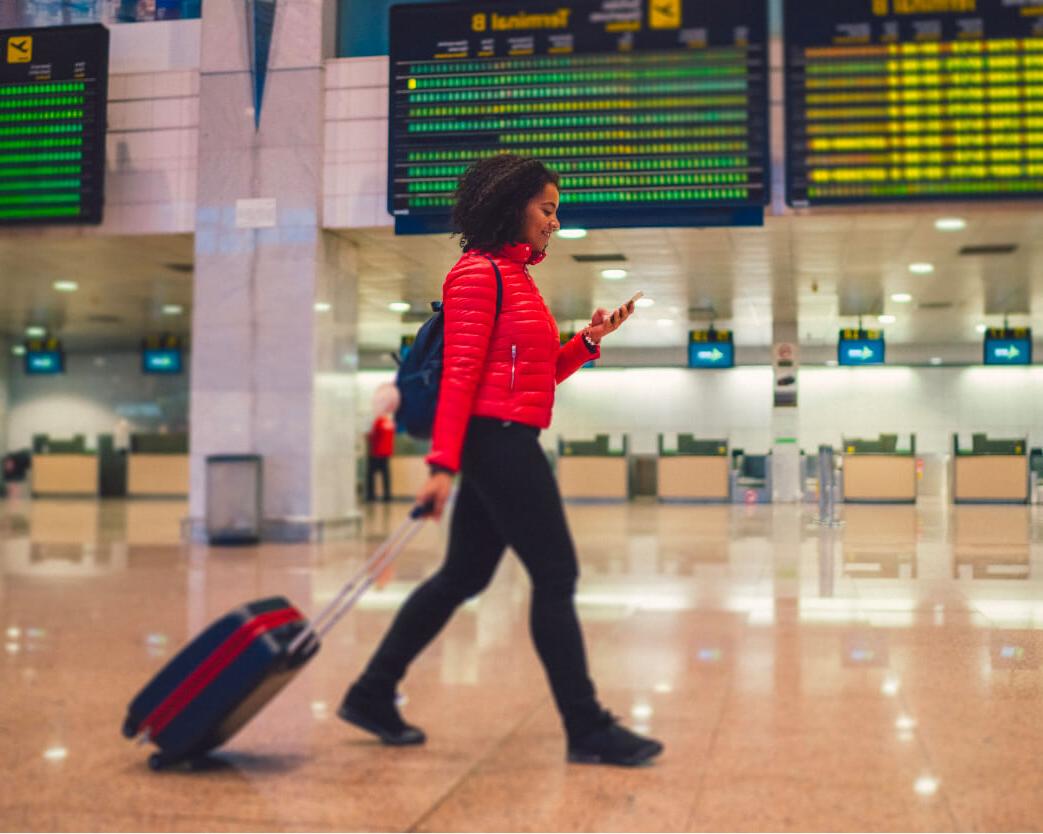 Student in airport with briefcase and cell phone